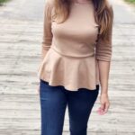 feminine classy homemaker outfit of dark wash jeans and neutral peplum style 3/4 sleeve top and booties for country living