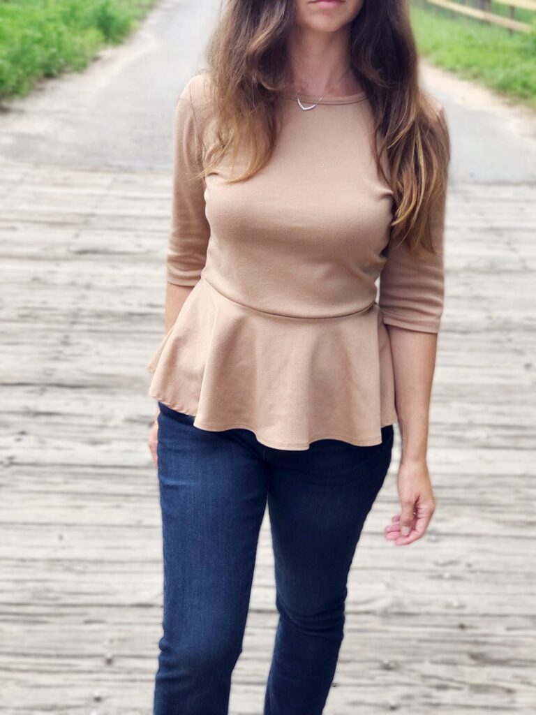 feminine classy homemaker outfit of dark wash jeans and neutral peplum style 3/4 sleeve top and booties for country living