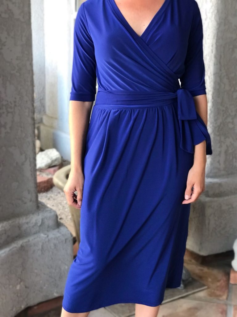blue midi length wrap dress with elbow length sleeves and a waist tie