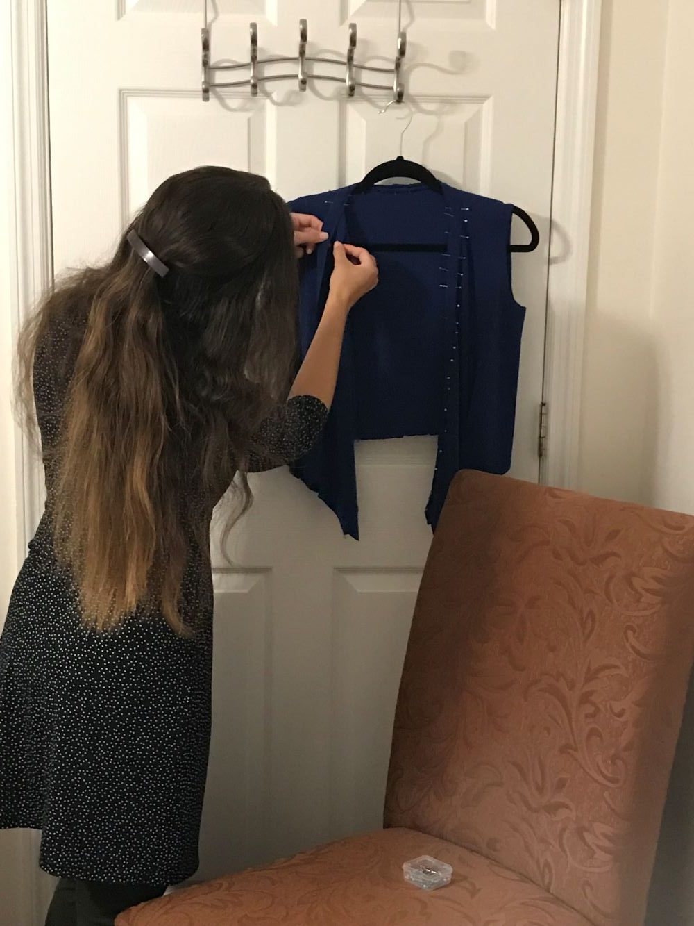 seamstress pinning and sewing a dress